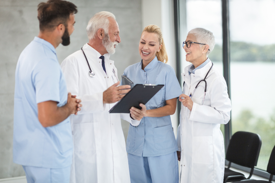 A nurse, two physicians and a care technician reviewing a chart together