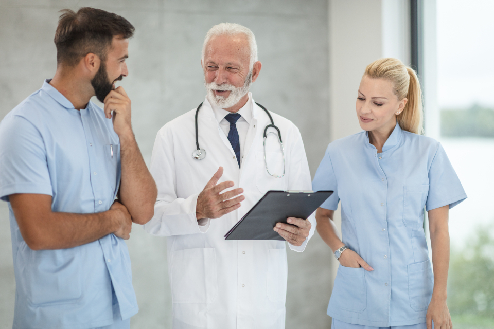 Nurses and a physician talking through a patient handoff